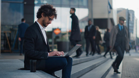 Businessman_Working_on_a_Laptop_While_Sitting_on_Steps